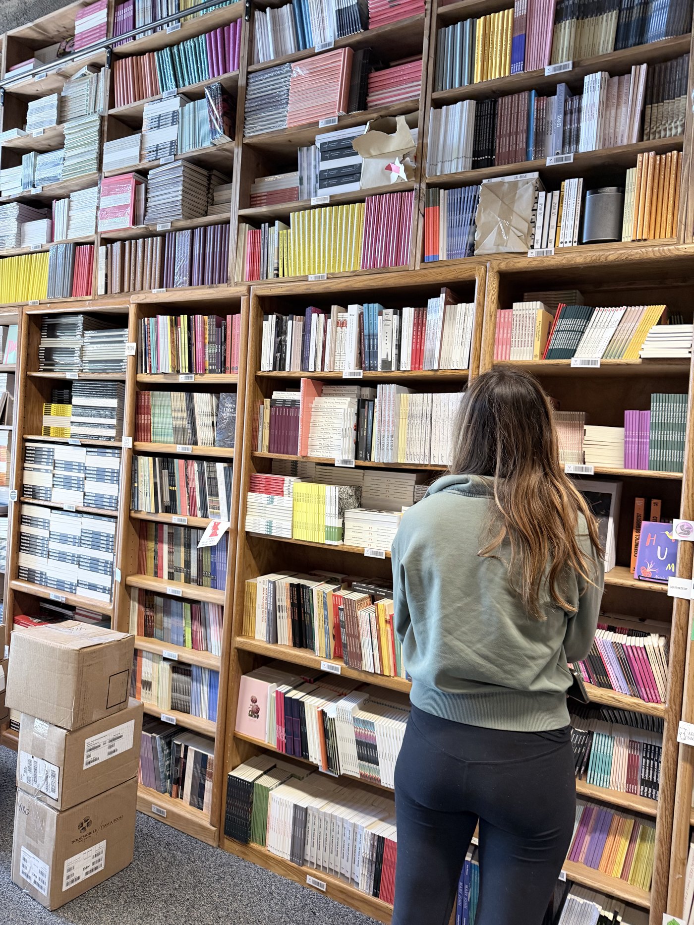 A visitor browsing shelves at Asterism, Seattle